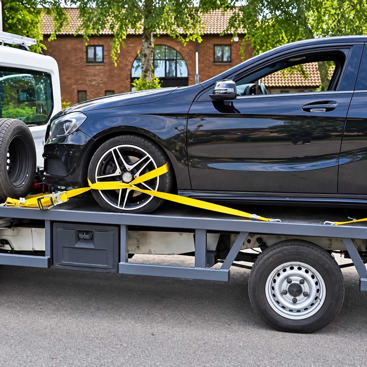 Wheel strap fitted around the front tyre of a black car